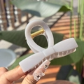 Dettaglio di un fermaglio per capelli a fiocco bianco crema con molla in metallo - Grigio Cemento Clip Fiocco Dritto