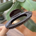 Close-up of a 10cm glossy dark coffee hair claw clip with a hollow oval design - 10cm / Chocolate