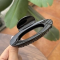 Detailed view of the 10cm hollow oval glossy black hair claw clip held in hand - 10cm / Glossy Black