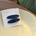 Close-up of star-patterned oval acetate hair clips with silver glitter and gold text - Deep Space Blue