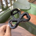 Close-up of a glossy black heart bow hair claw clip with a sturdy metal spring - Glossy Black