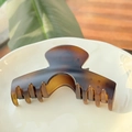 Vue détaillée d'une grande pince à cheveux mate motif écaille sur une assiette beige - Arche Carrée XL Boucle Papillon / Écaille de Tortue Mate