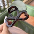 Detail of tortoise shell heart hair claw clip with bow shape and clear resin texture - Glossy Red Brown