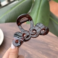 Dettaglio della molletta per capelli tartarugata marrone con design elegante a onde - Rosso Marrone Lucido