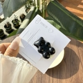 Detail van de schattige zwarte beertje haarclip op displaykaart bij natuurlijk buitenlicht - Donkere Pruim Gummybeertje Clip