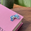 Detail showing blue marble acetate bow hair clip with intricate hollow cut-out patterns - Bowknot Duckbill Clip / Blue & White Tie-Dye