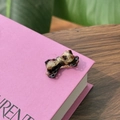 Macro detail of tortoiseshell acetate bow clip with gold metal base on book - Bowknot Duckbill Clip / White Tortoiseshell