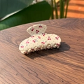 Detailansicht der Haarklammer mit Kirschmuster und Kristallen auf Holzgrund - Rosa Kirsche mit Strass - Vasenstil Haarkralle