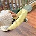 Detail eines gelben gepolsterten Stirnbands mit Wabenstruktur und handgefertigtem Etikett - Gansgelb