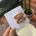 Detail van amber marmeren ovale haarclips op een merk display kaartje - Karamelbruin Gestreepte Ovale Clip