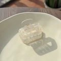 Detailopname van doorschijnende parelmoer haarklem met gouden metalen veer - Off-wit