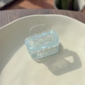 Close-up of translucent light blue square hair claw clip with pearlescent marble texture - Mint Blue Green