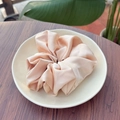 Gros plan du chouchou en soie rose pêche avec texture nacrée sur une assiette - Rose Étoilé