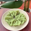 Close-up of grass green scrunchie with soft fabric texture on a white plate - Willow Green
