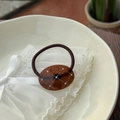 Detail of an oval amber acetate hair tie with gold grid patterns and crystal rhinestones - Transparent Caramel Brown