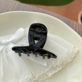 Macro shot of black glossy hair claw clip with golden Barrette la France logo lettering - Glossy Black