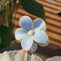 Handheld light blue flower hair claw clip with jelly texture shown in natural sunlight - Blue Petal White Edge Solid Color Flower Claw