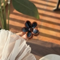 Detailed close-up of amber translucent resin flower hair claw with a glossy black center - Black Petal Tortoiseshell Edge Flower Claw (Small)