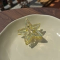 Close-up of a holographic star hair claw clip with clear iridescent acrylic texture - Iridescent Yellow Star Clip