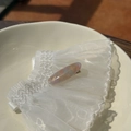 Detail of a handmade marble acetate hair clip with gold lettering on white lace - Pink Yellow Blue