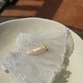 Detail of handmade acetate duckbill hair clip with golden label and pearlescent texture - Cream White