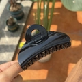 Close-up of a large glossy black hair claw clip with strong teeth for firm hold - Bright Black