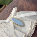 Elegant blue oval hair clip with lace trim and ribbon bow on dark wood background - Khaki Hollow-Blue Clip