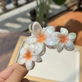 Detailansicht der irisierenden Blumen-Haarklammer mit drei weißen Plumeria-Blüten - Orange Irisierende Blume