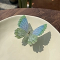 Close-up of butterfly hair claw clip with blue-green gradient wings and acrylic texture - Painted Blue Green