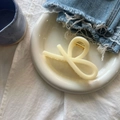 Close-up of cream resin hair claw clip with cross knot design on decorative plate - Creamy Yellow Ribbon Claw Large