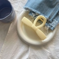 Gros plan d'une pince à cheveux nœud en résine crème sur un plateau de présentation blanc - Jaune Crème Barre Nœud Très Grande