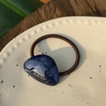Detail eines dunkelblauen Harz-Haargummis mit France Handmade Goldtext auf Keramik - Blauschwarz Webstruktur - Goldetikett Haarseil