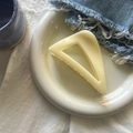 Detailed view of a minimalist cream-colored hollow triangle hair claw clip on a ceramic tray - Creamy Yellow Slant Triangle Large