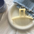 Detail of cream white matte hair claw clip on white ceramic plate with denim accents - Creamy Yellow Ji Style Large