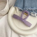 Détail de la pince à cheveux violette en forme de nœud avec ressort doré sur plateau - Pince Nœud de Barre - Grande