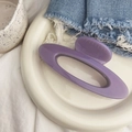 Detail of a shiny purple resin hair claw clip placed on a white ceramic plate - Oval Hollow Out - Large / approx. 12.5cm