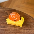 Cute yellow and orange snail-shaped hair claw clip with a glossy cartoon design - Smiley Snail Hair Claw