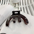 Elegante pinza per capelli in acetato marrone scuro con scritte dorate su sfondo bianco - caffè