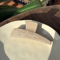 Macro shot of khaki heart heartbeat patterned plastic hair claw clip on ceramic dish - Khaki (Khaki Base White Signal)
