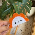 Haarklammer aus Acetat in Sonnenblumenform mit Smiley-Design in natürlicher Umgebung - Orange Sonnenblume Smiley