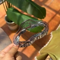 Macro detail of a large smoky grey wavy claw clip with a strong gold metal spring - Transparent Blue-Black