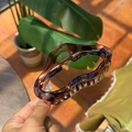 Detail view of a large brown tortoiseshell resin hair claw clip with wave edges and metal spring - Transparent Tortoise