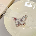 Detail of a 3D butterfly hair clip with marble textured acetate and gold metal duckbill - Beige-Red-Green
