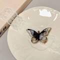 Close-up of hollow butterfly acetate hair clip with elegant marble pattern and gold metal clip - Glitter Black