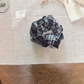 Close-up of British retro plaid scrunchie with classic black, white and red patterns - White & Black Plaid