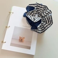 Coletero minimalista a cuadros azules y blancos con tela suave sobre un cuaderno - Raya Azul Blanco Denim Azul Bloque de Color