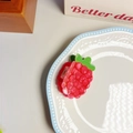 Detailed view of a raspberry-shaped hair claw clip with a vibrant red and green finish - Raspberry