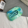 Détail d'une grande pince à cheveux ovale avec texture acétate marbrée bleu-vert - Dégradé Vert d'Eau