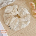 Elegante elastico in pizzo color crema con ricamo floreale su sfondo di legno chiaro - Scrunchie Motivo Classico / Bianco