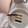 Macro detail of amber acetate hair clip with handmade France gold stamp on a white plate - Gold Label Barrette / Transparent Coffee
